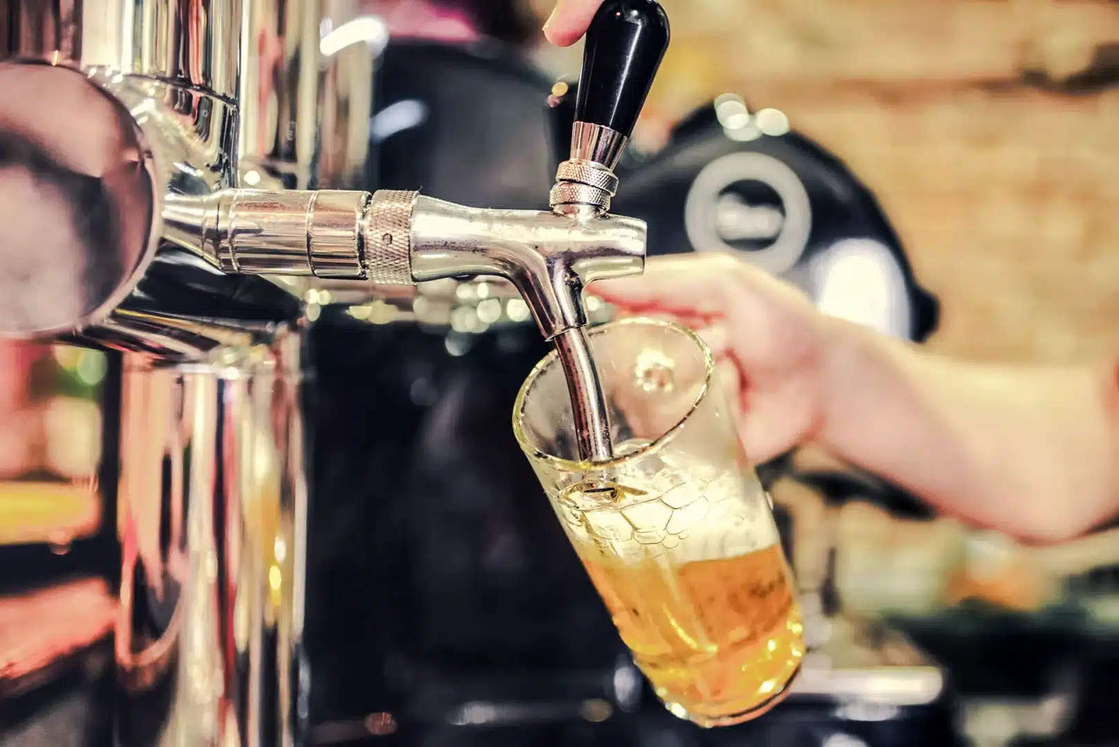 Bei einer Zapfanlage wird ein Bier in ein Glas eingeschenkt.