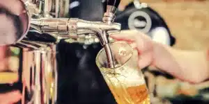 Bei einer Zapfanlage wird ein Bier in ein Glas eingeschenkt.
